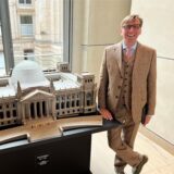 Michael Sacher am Modell des Reichstages im echten Reichstag, in dem er als Abgeordneter arbeitet.