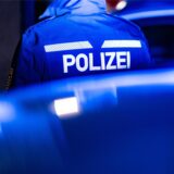 Ein Polizist wird von hinten angeleuchtet.