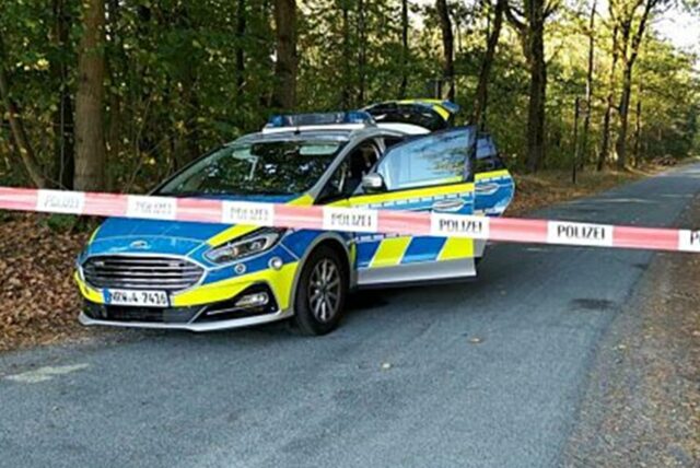 Ein Polizeiauto steht an einem mit Flatterband abgesperrten Waldweg (SYMBOLBILD)