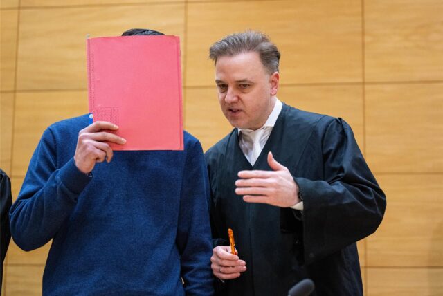 Der Hauptangeklagte im Prozess um den Tod von Philippos in Bad Oeynhausen steht mit seinem Anwalt Burkhard Benecken aus Marl im Gerichtssaal.