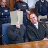 Anwalt Christoph Krekeler sitzt im Gerichtssaal neben dem Polizisten Fabian S., der in Dortmund die tödlichen Schüsse auf Mouhamed Dramé abgefeuert hat.