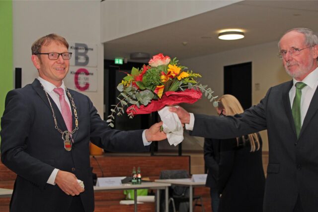 Altersvorsitzender Rainer Hotz (Grüne, rechts) überreicht Blumen an Lothar Christ.