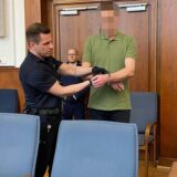 Ein Justizbeamter liegt einem Mann Handschellen an.