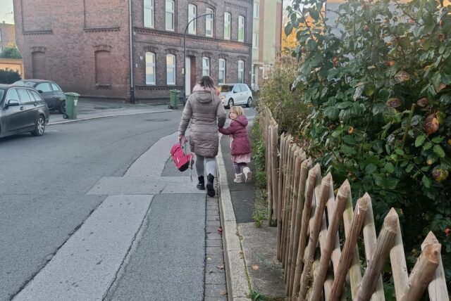Eine Mutter und ihr Kind gehen auf einem sehr schmalen Gehweg an der Sölder Straße.