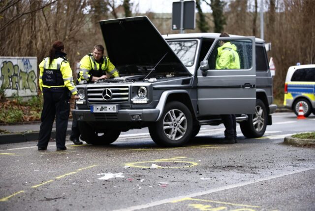Polizisten untersuchen einen Mercedes, der an der Unfallstelle steht.