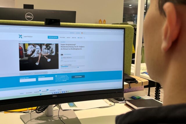 Ein Mann sitzt vor einem Computerbildschirm.