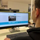 Ein Mann sitzt vor einem Computerbildschirm.