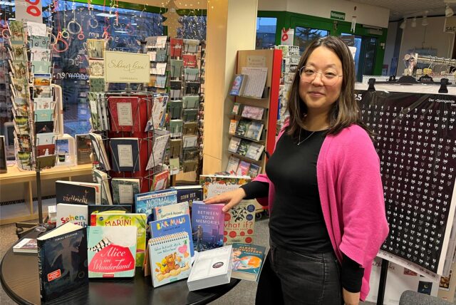 Tiphaine Scholz neben vielen Büchern,