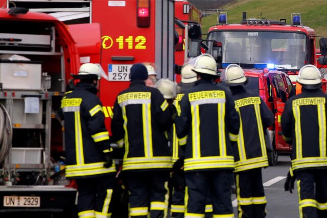 Feuerwehrleute stehen an einem Fahrzeug der Feuerwehr Kamen.