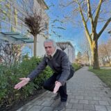 Anwohner Thomas Averbeck hockt an der Bertha-von-Suttner-Allee in Unna und zeigt mit ausgebreiteten Händen einen Abstand an.