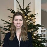 Patricia Schimschewski steht vor einem geschmückten Tannenbaum.