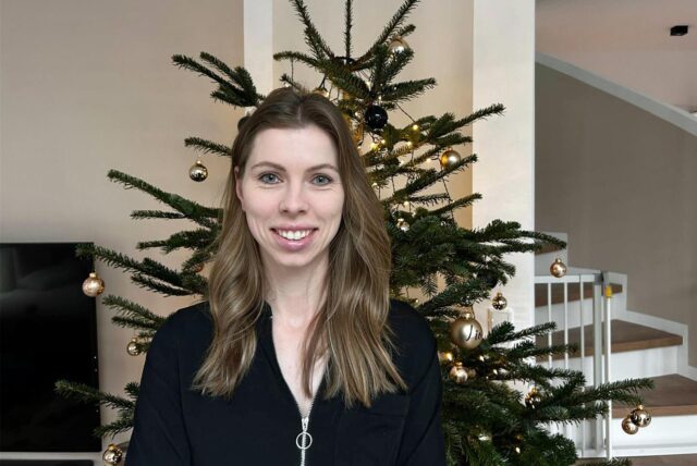 Patricia Schimschewski steht vor einem geschmückten Tannenbaum.