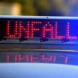 Auf einem Polizeifahrzeug warnt eine Leuchtschrift vor einer Unfallstelle (Illustration).