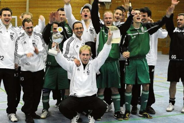 Spieler präsentieren einen Pokal.