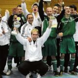 Spieler präsentieren einen Pokal.