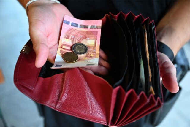 Jemand nimmt Geld aus seinem Portemonnaie.