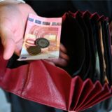 Jemand nimmt Geld aus seinem Portemonnaie.
