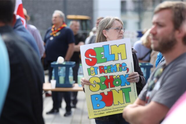 Eine Frau trägt ein Schild
