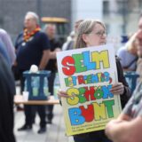 Eine Frau trägt ein Schild