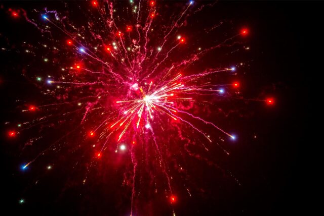 Eine Feuerwerksrakete explodiert über dem Nachthimmel.