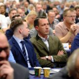 Der Bundestagsabgeordnete Matthias Helferich sitzt beim AfD-Parteitag in Marl-Sinsen zwischen anderen Parteimitgliedern.