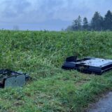 Zwei Fernseher auf einem Feld neben einer Straße.