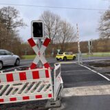 Zwei Autos fahren in Unna über den Bahnübergang an der Heerener Straße. Nach Bauarbeiten am Radweg steht vor Ort noch Absperrbaken