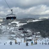 Menschen fahren Ski in Winterberg. Über der Piste sind Lifte.
