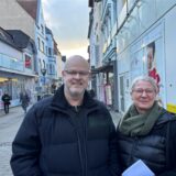 Ein Mann und eine Frau lächeln in der Schwerter Innenstadt freundlich in die Kamera.