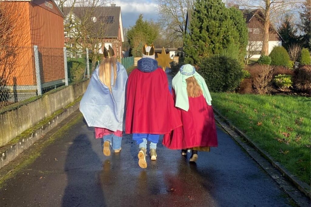Sternsinger, die in Fröndenberg unterwegs sind. Man sieht drei Personen von hinten Sternsinger, die in Fröndenberg unterwegs sind. Man sieht drei Personen von hinten