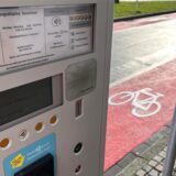 An einem rot markierten Radweg steht ein Parkscheinautomat