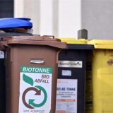 Abfalltonnen stehen an einem Haus.