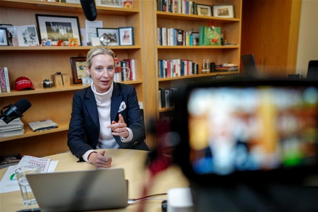 Mit Podcast-Mikrofon und Laptop schaltete sich AfD-Chefin Alice Weidel von ihrem Bundestagsbüro aus in den Live-Talk mit X-Chef Elon Musk. Mit Podcast-Mikrofon und Laptop schaltete sich AfD-Chefin Alice Weidel von ihrem Bundestagsbüro aus in den Live-Talk mit X-Chef Elon Musk.