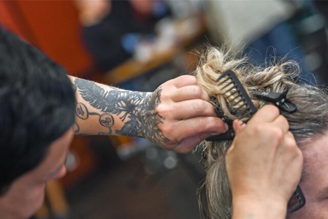 Eine Friseurin legt einer Kundin die Haare.