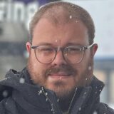 Reporter Mathias Gaumann hält sein Handy und die gekaufte Cola Dose direkt in die Kamera und lächelt.