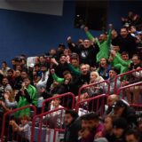 Fans jubeln auf einer Tribüne.