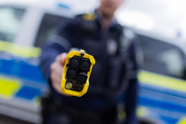 Ein Polizist zeigt einen Taser.