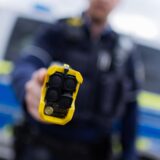 Ein Polizist zeigt einen Taser.