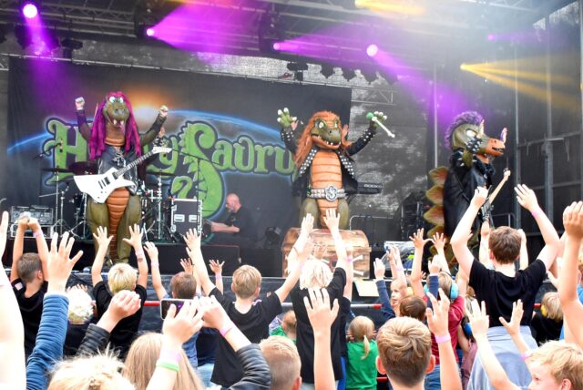 Kinder stehen bei einem Auftritt der Band „Heavysaurus“ vor der Bühne.