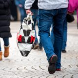Ein Mann mit einer Einkaufstüte geht während des verkaufsoffenen Sonntags durch die Innenstadt.