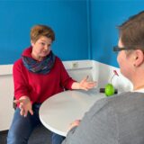 Gundula Lauf (links) demonstriert mit offenen Armen eine offene Gesprächssituation.