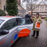 Mailin Finke Branquinho, Standortleiterin bei cambio in Dortmund, und Heike Proske, Superintendentin des Evangelischen Kirchenkreises, stehen neben einem der beiden Carsharing-Autos, die an der Jägerstraße in Dortmund stationiert sind.