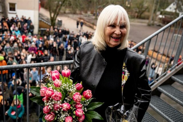 Verena Zapf, Köpenicker Lehrerin, bekommt zu ihrem 80. Geburtstag ein Ständchen von den Schülern der Evangelischen Schule Köpenick. Sie hält einen Blumenstrauß aus Tulpen in den Händen.