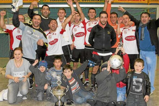 Jubelten über den Gewinn der Hallenstadtmeisterschaft Bergkamen: die Spieler von Gurbet Spor Bergkamen und ihre jungen Fans. Das Team setzte sich im Finale mit 2:0 gegen den Favoriten VfK Weddinghofen durch.