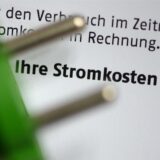 Ein grüner Stromstecker liegt auf einer Stromrechnung.