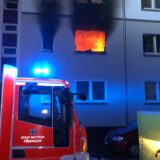 Aus einem Fenster im ersten Stock eines Hauses in Bottrop sind Flammen zu sehen. Die Feuerwehr ist im Einsatz.