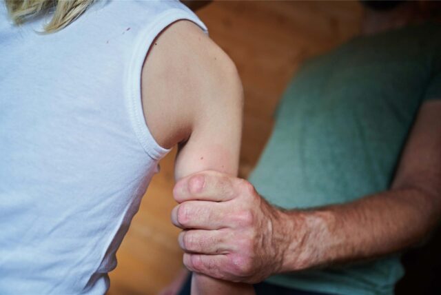 Ein Mann hält ein Kind fest am Arm