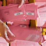 Eine Kiste mit roten Briewahl-Umschlägen.
