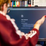 Eine Frau sitzt vor einem Computermonitor, auf dem „Kein Internet“ angezeigt wird.