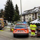 Einsatzkräfte stehen vor einem Mehrfamilienhaus im Ennepe-Ruhr-Kreis.